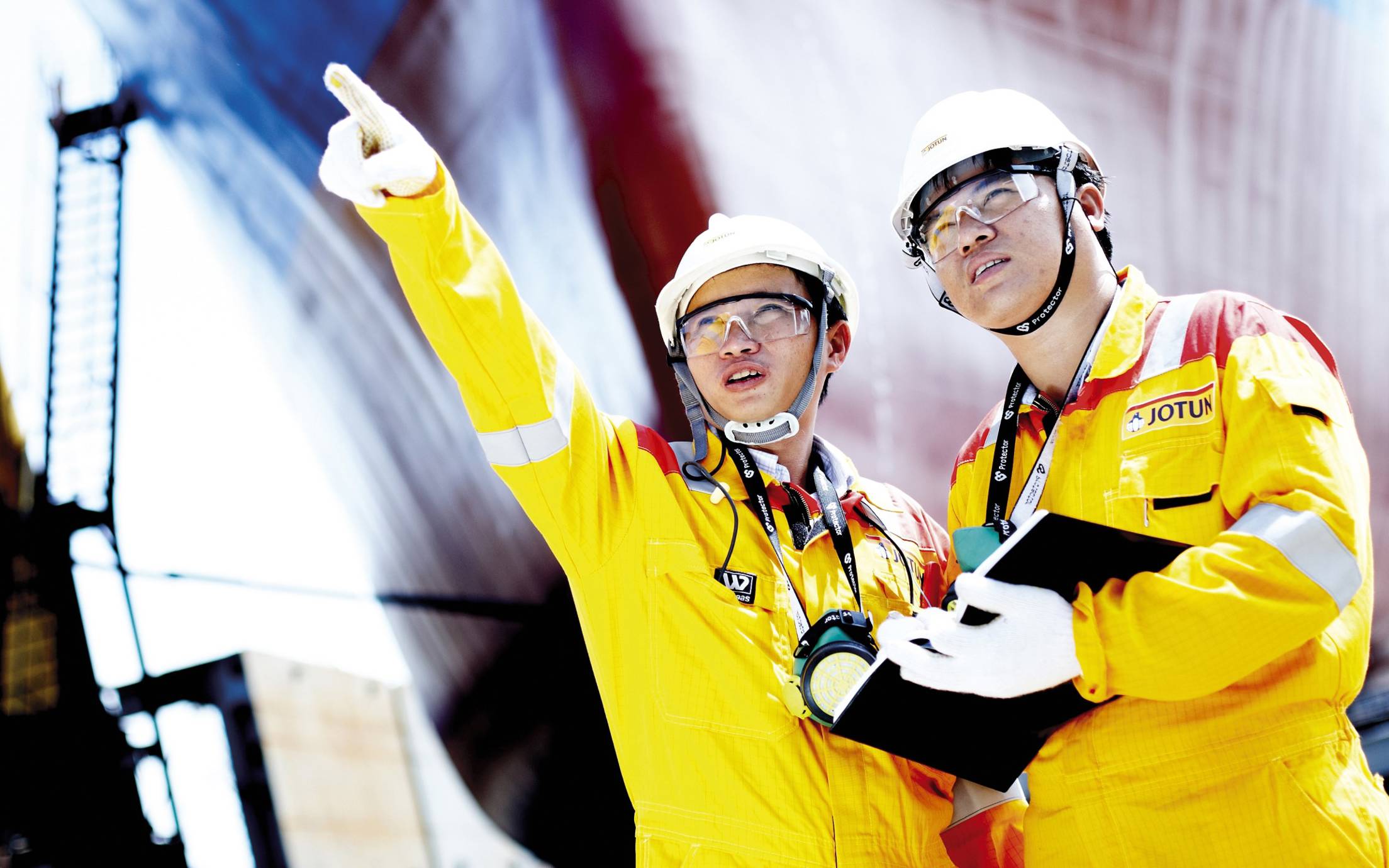 Two engineers, yellow overalls and hard hats