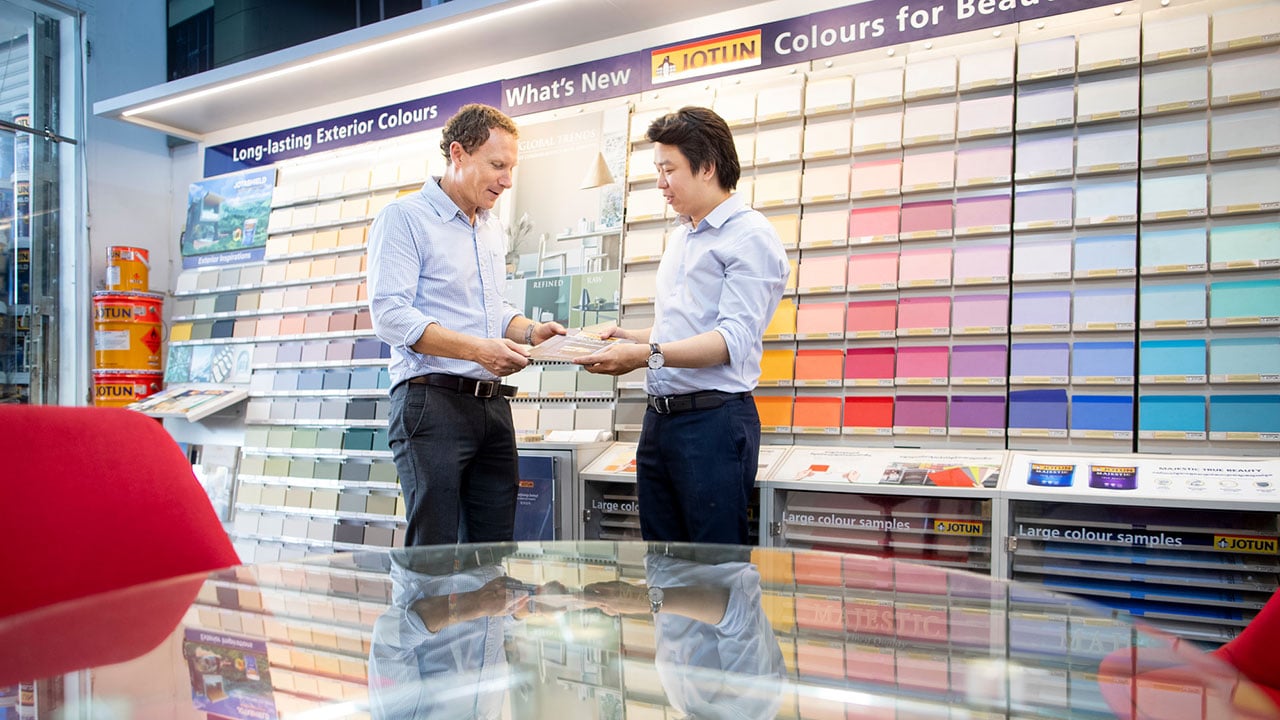 Jotun employee shows different colours to a customer in Cambodia